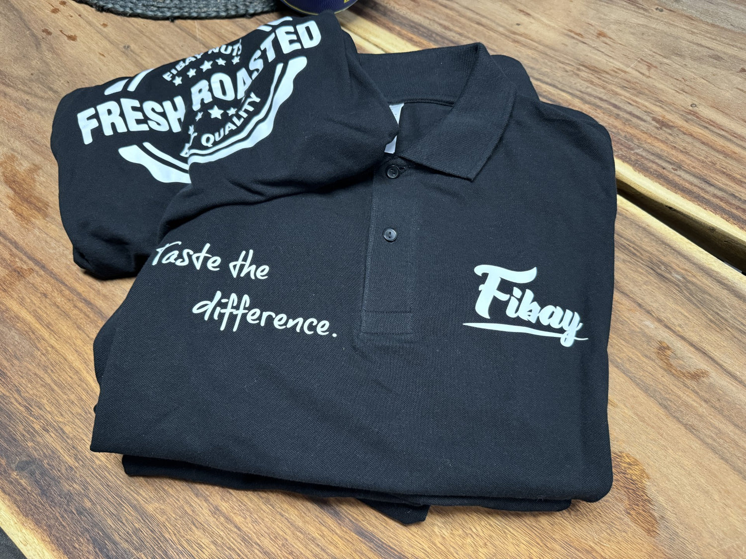 Schwarzes Polo-Shirt und T-Shirt mit den Aufschriften „Fikay“ und „Taste the difference.