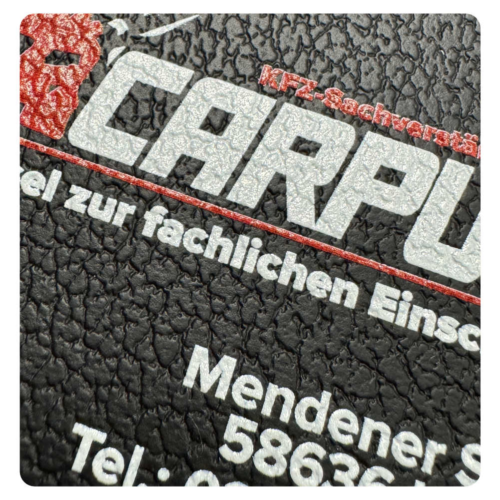 Detailaufnahme des Carputt-Logos auf einer strukturierten schwarzen Lederhülle mit Kontaktdaten des Unternehmens